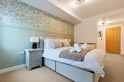 a bedroom with a large bed with a green accent wall at Luxurious City Centre Cosy WiFi and Netflix in Chesterton