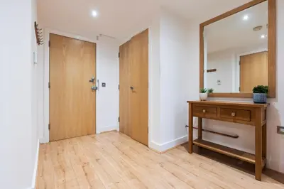 a bathroom with a wooden vanity and a mirror at Luxurious City Centre Cosy WiFi and Netflix in Chesterton