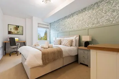 a bedroom with a large bed and a desk at Luxurious City Centre Cosy WiFi and Netflix in Chesterton