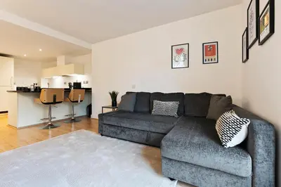 a living room with a couch and a kitchen at Luxurious City Centre Cosy WiFi and Netflix in Chesterton