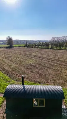 a black tank in front of a large field at Bramley Cabin Suffolk Relaxing Getaway in Woodbridge