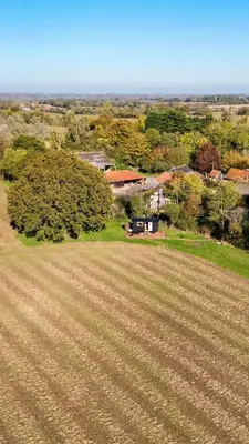 an aerial view of a field with a house and trees at Bramley Cabin Suffolk Relaxing Getaway in Woodbridge