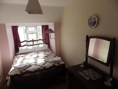 a small bedroom with a bed and a mirror at Crow Corner in Yoxford