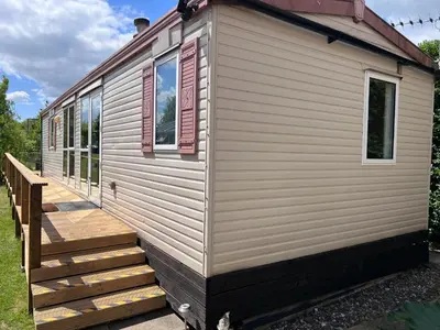 a tiny house with a staircase and windows at The static, it is what it is! in Wicken