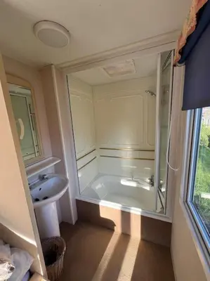 a bathroom with a bath tub and a sink at The static, it is what it is! in Wicken
