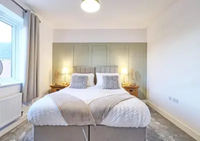 a bedroom with a large white bed with two lamps at Well-Located 4 Bed Property in Colchester, Suited for Families and Business Travelers in Colchester