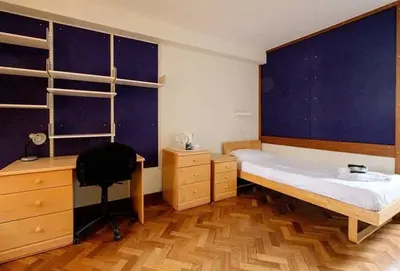 a bedroom with a bed and a desk and a chair at Sidney Sussex College, Cambridge in Cambridge