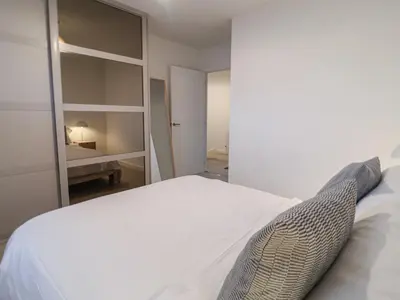 a bedroom with a white bed and a mirror at Inishnee House in Ipswich