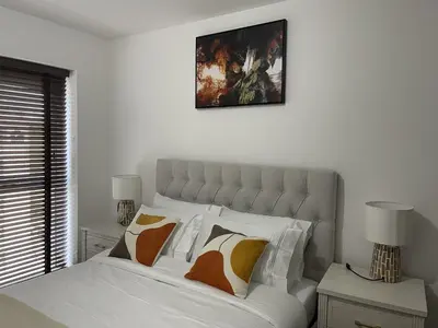 a bedroom with a bed with white sheets and pillows at The Comfort, with Free Parking, Harlow in Harlow