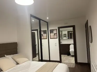 a bedroom with a bed and some mirrors at The Comfort, with Free Parking, Harlow in Harlow