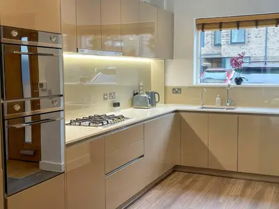 a kitchen with stainless steel appliances and wooden floors at Central Luxury Peaceful Home With Driveway Parking - Cambridge Homehost in Cambridge
