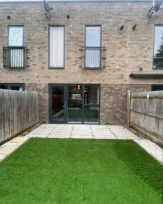 a brick building with a door and a grass yard at Central Luxury Peaceful Home With Driveway Parking - Cambridge Homehost in Cambridge