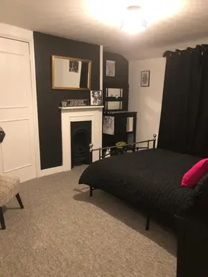 a bedroom with a bed and a fireplace at Susies Place in Thaxted
