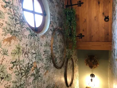 a wall with two mirrors on a wall with flowers at Susies Place in Thaxted