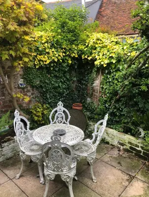 a wrought iron table and chairs on a patio at Susies Place in Thaxted
