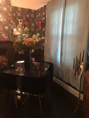 a dining room with a table with a vase of flowers at Susies Place in Thaxted