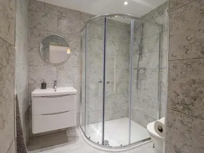 a bathroom with a shower with a toilet and a sink at Farmer's Rest in Ely