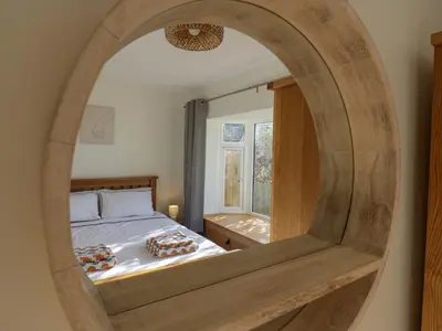 a bedroom with a bed and a mirror at Farmer's Rest in Ely