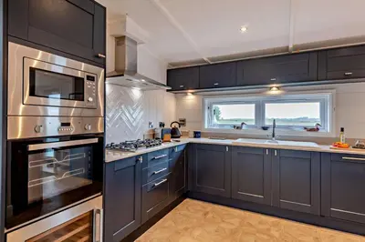 a kitchen with black cabinets and a stove top oven at 2 Bed in Welney oc-k30123 in Welney