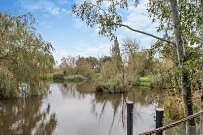 a view of a river with trees and a fence at 2 Bed in Welney oc-k30123 in Welney