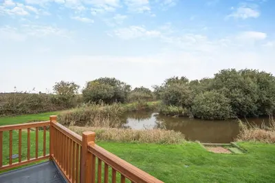 a wooden deck with a view of a river at 2 Bed in Welney oc-c30124 in Welney