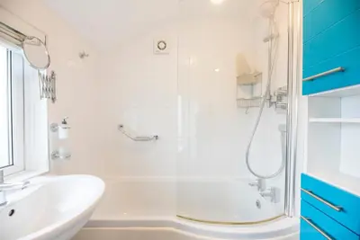a bathroom with a shower and a tub and a sink at Telford, Aldeburgh in Aldeburgh