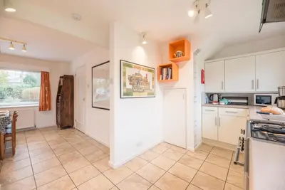 a kitchen with white cabinets and a tile floor at Telford, Aldeburgh in Aldeburgh