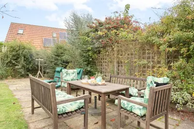 a wooden table with two chairs and a table with at Telford, Aldeburgh in Aldeburgh