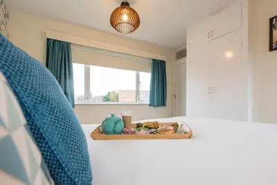 a bed with a tray of food and a window at Telford, Aldeburgh in Aldeburgh