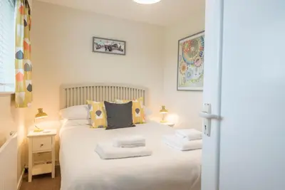 a bedroom with a bed with white sheets and pillows at Telford, Aldeburgh in Aldeburgh