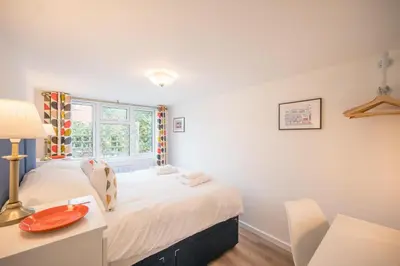 a bedroom with two beds and a desk and a window at Telford, Aldeburgh in Aldeburgh