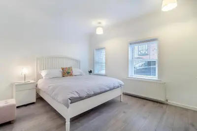 a white bedroom with a bed and a window at 2 Bed in Felixstowe oc-m30281 in Felixstowe