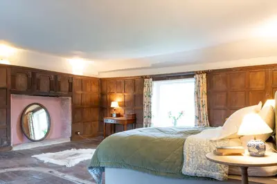 a bedroom with a bed and a window and a mirror at River House in Kersey