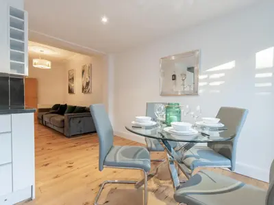 a kitchen and living room with a glass table and chairs at Cosy flat in Leigh - Pass the Keys in Southend-on-Sea