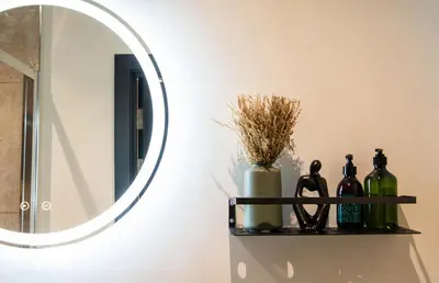 a mirror on a wall with bottles on a shelf at Thetford Hive - Premium Self Check-In Aparthotel in Thetford