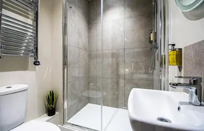a bathroom with a shower and a sink and a toilet at Thetford Hive - Premium Self Check-In Aparthotel in Thetford