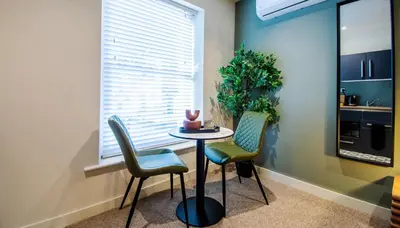 a small table and chairs in a room with a window at Thetford Hive - Premium Self Check-In Aparthotel in Thetford