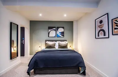 a bedroom with a bed and some pictures on the wall at Thetford Hive - Premium Self Check-In Aparthotel in Thetford