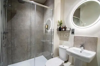 a bathroom with a shower and a toilet and a sink at Thetford Hive - Premium Self Check-In Aparthotel in Thetford