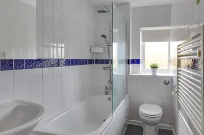 a bathroom with a tub and a toilet and a sink at Homely Apartment in Harlow in Great Parndon
