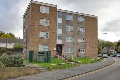 a brick building on the side of a street at Homely Apartment in Harlow in Great Parndon