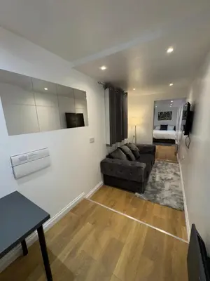 a living room with a couch and a television at M18 Escape in Havering atte Bower