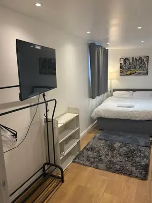 a bedroom with a bed and a flat screen tv at M18 Escape in Havering atte Bower