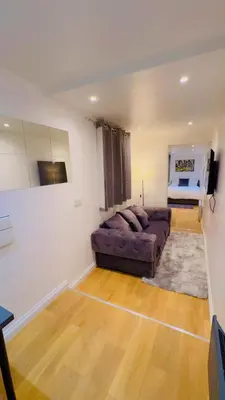 a living room with a purple couch in a room at M18 Escape in Havering atte Bower