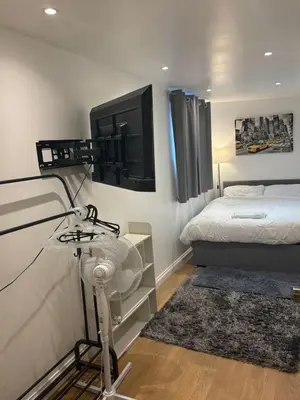 a bedroom with a bed and a tv on the wall at M18 Escape in Havering atte Bower