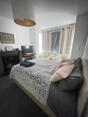 a bedroom with a bed and a fireplace at Artsy Minimalist Suite in Southend-on-Sea
