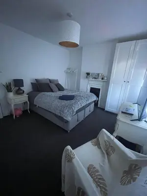 a large bedroom with a bed and a fireplace at Artsy Minimalist Suite in Southend-on-Sea