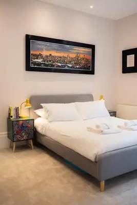 a bedroom with a bed with a picture on the wall at Modern 1Bed Apartment supercentral in Cambridge