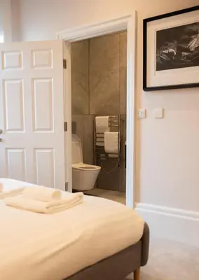 a bedroom with a bed and a bathroom with a toilet at Modern 1Bed Apartment supercentral in Cambridge