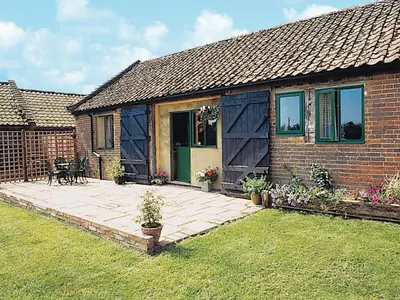 a brick house with a patio in the yard at The Cart Shed - E1768 in Westleton